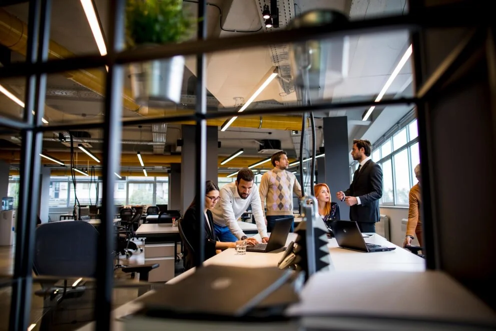modern office setting with employees collaborating at desks